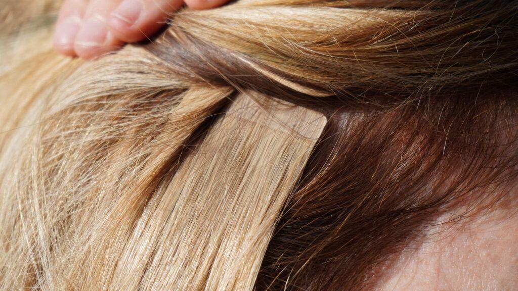 Haarverlängerungen bei blonden Mädchen, Frauenhaare, professionell vom Friseur, Tape-in-Verlängerungen