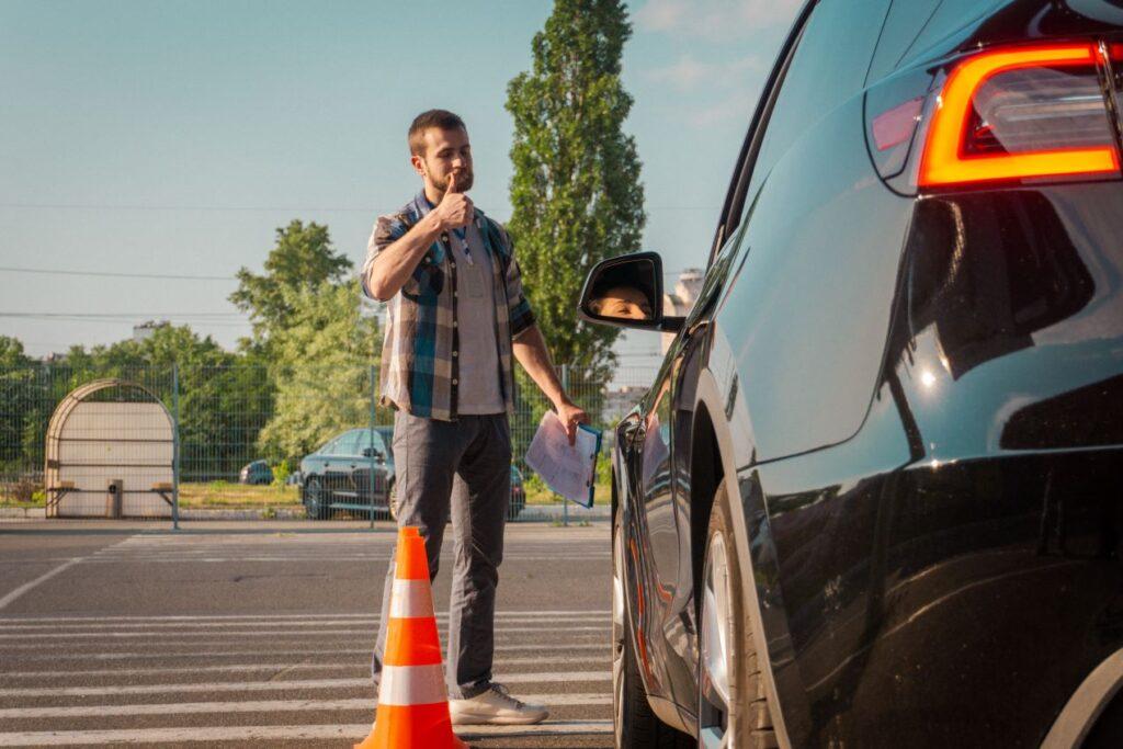 Ein Fahrlehrer gibt einem Fahrschüler während einer praktischen WAB-Weiterbildung ein positives Feedback auf einem Übungsplatz.