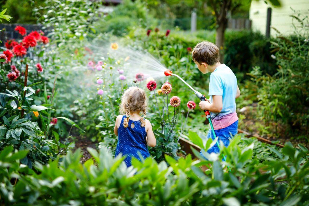 Kinder gießen bunte Blumenbeete | Sandfilteranlage
